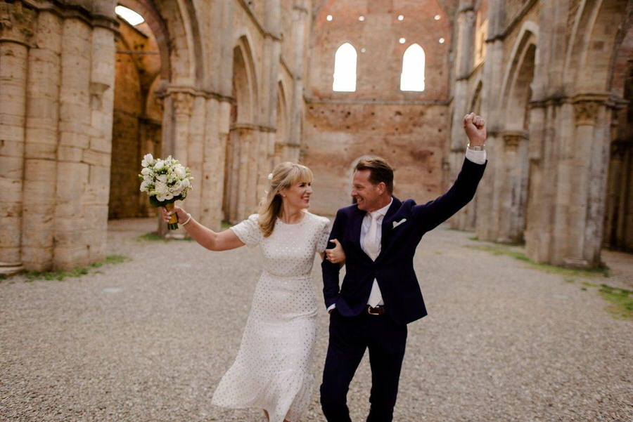 happy wedding couple at san galgano abbey in tuscany