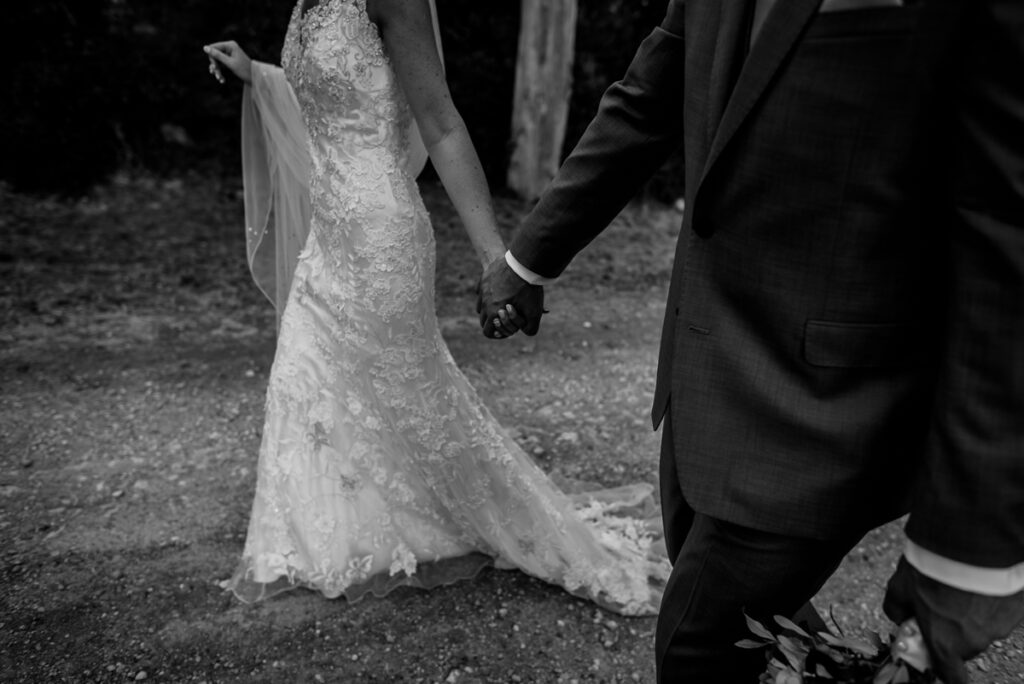 bride and groom walking together hand in the hand black and white